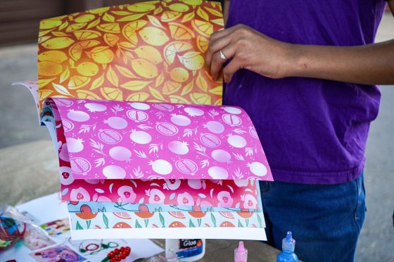 A close up of a person flipping through decorated sheets of paper.